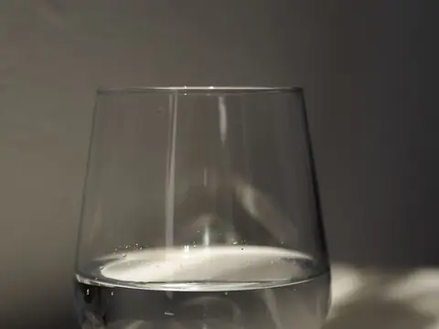 A glass of water lit by a beam of sunlight
