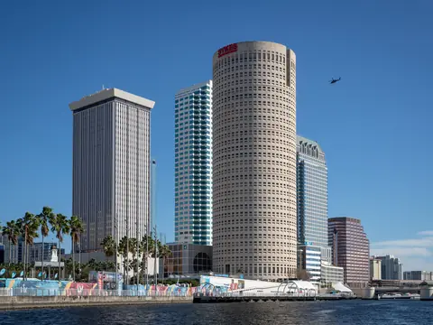 Downtown Tampa towers and palms along the water under a deep blue sky