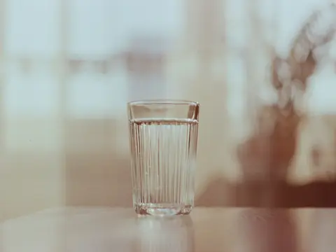 A glass of water on a table in soft afternoon light