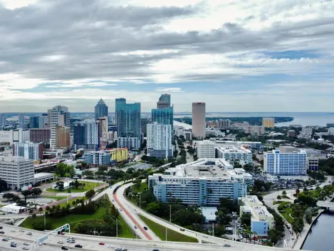 An aerial view of downtown Tampa, its highways and the river under clouds