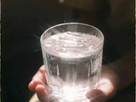 Hands holding a clear glass of water